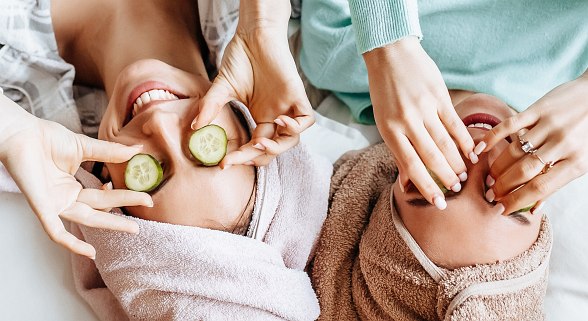 Zwei Frauen mit Handtuch auf dem Kopf und Gurkenscheiben auf den Augen
