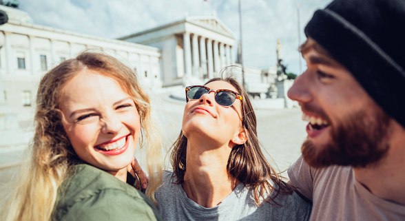 Zwei junge Frauen und ein junger Mann vor dem Wiener Parlament