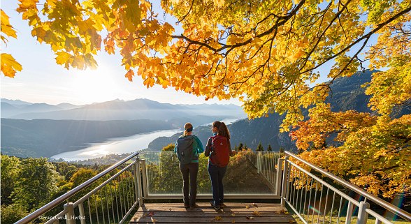 Zwei Frauen mit Wanderrucksack auf einer Aussichtsplattform am Millstättersee