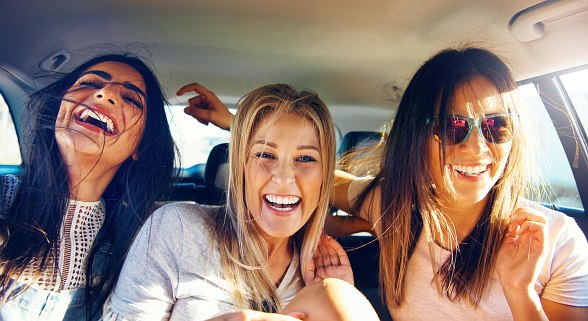 Freundinnen lachen auf Ihrer Reise im Auto