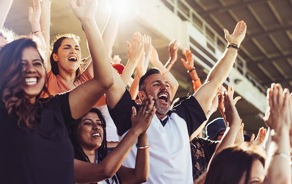 Menschen jubeln mit Händen in der Höhe