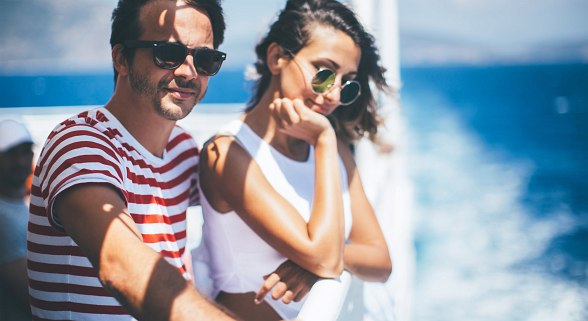 Paar ist auf einer Kreuzfahrt und sieht auf das Meer hinaus