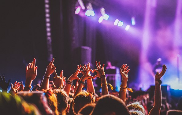 Menge bei Konzert mit Händen in der Luft und Blick auf die Bühne