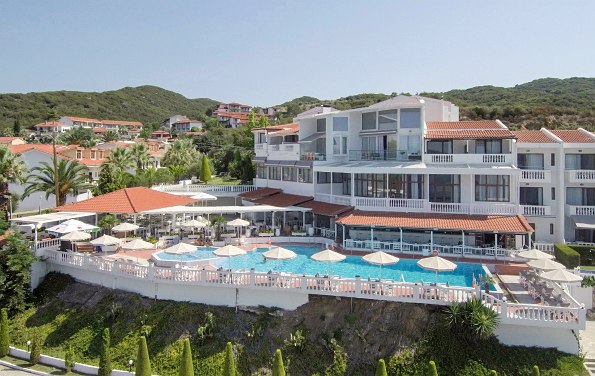 Hotel von außen mit Pool Liegen und Sonnenschirmen