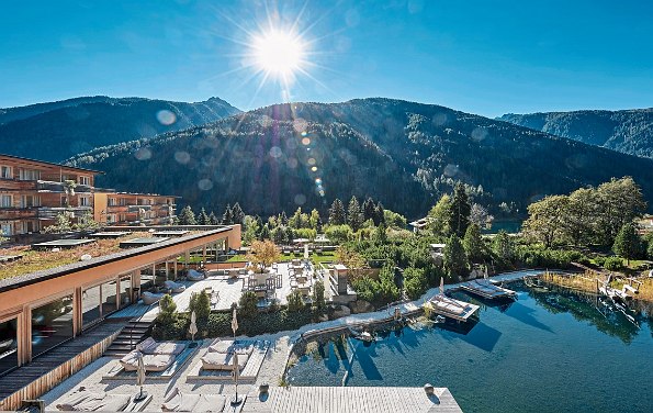 Hotel von außen mit See und Bergen im Hintergrund