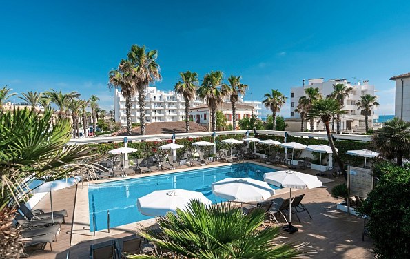 Pool mit Sonnenschirmen und Palmen