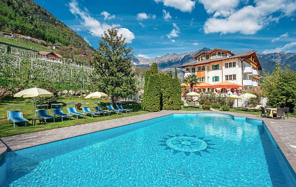 Pool mit Hotel, Bergen und blauem Himmel im Hintergrund 