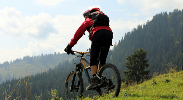 Mann auf dem Fahrrad mitten in den Alpen